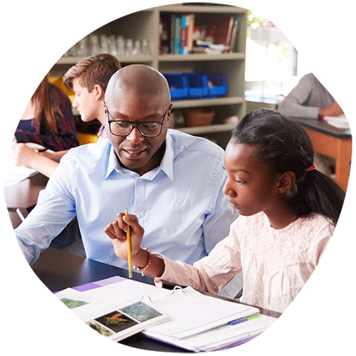 Teacher helping student at desk with notes binder