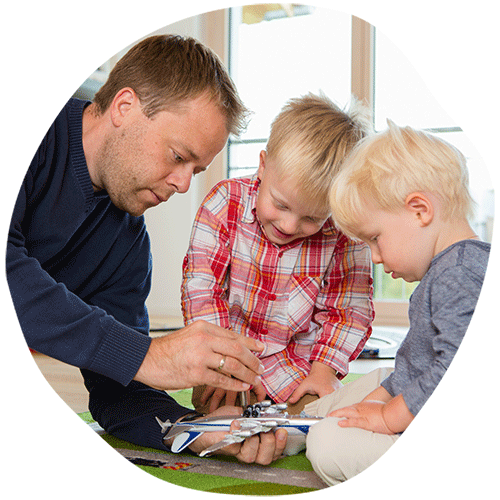 Father showing his two sons an airplane toy
