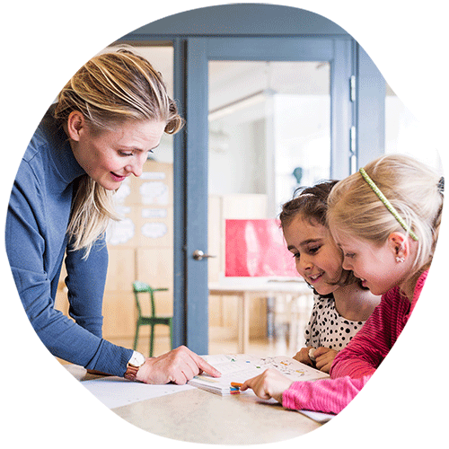 Teacher helping two elementary girls