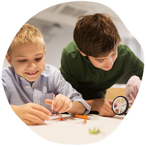 Two young boys building a model car