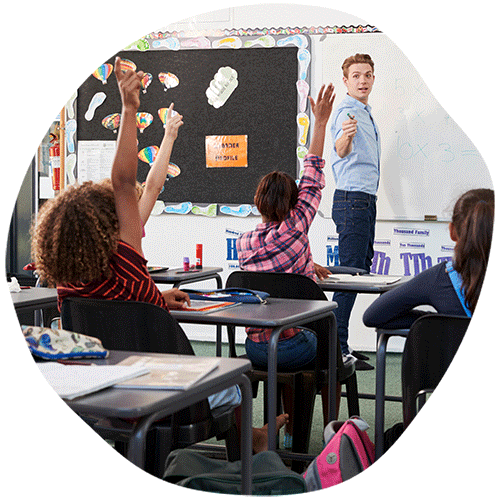 Teacher at front of classroom pointing to students