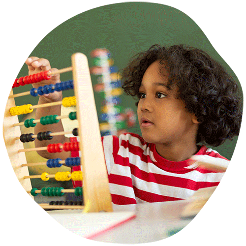 Young child learning math using an old abacus
