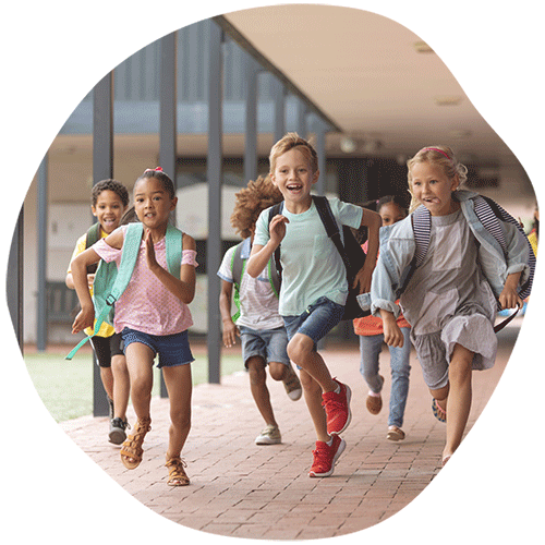 Class of children running down school hallway